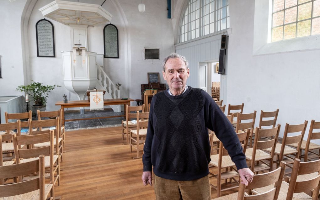 Man op leeftijd in een blauwe trui in een oud kerkje.