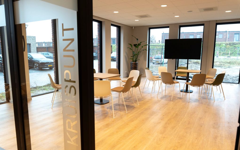 Kruispunt, een modern ingerichte zaal met stoelen en een scherm.