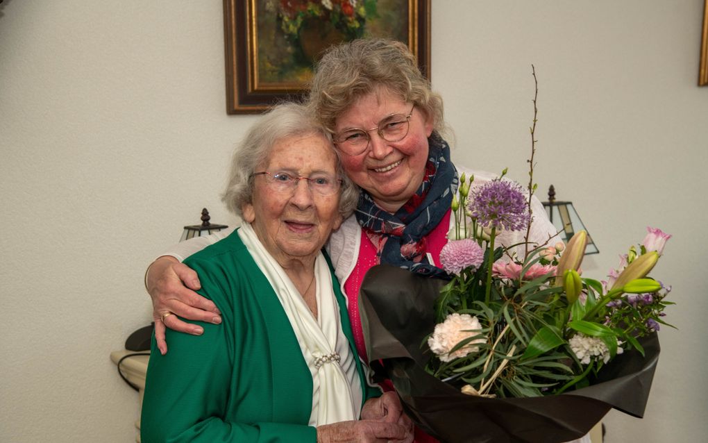 Dieuwertje de Heer (l.) geeft haar overbuurvrouw en vriendin Heintje van Renselaar een bos bloemen. „Ze voelt inmiddels als een zus voor mij.” beeld Bram van de Biezen