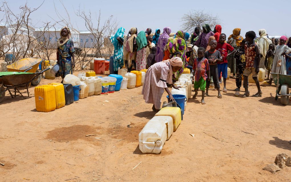 Sudanese vrouwen en kinderen staan in het vluchtelingenkamp Farchana in Tsjaad in de rij om water te halen. beeld AFP, Joris Bolomey