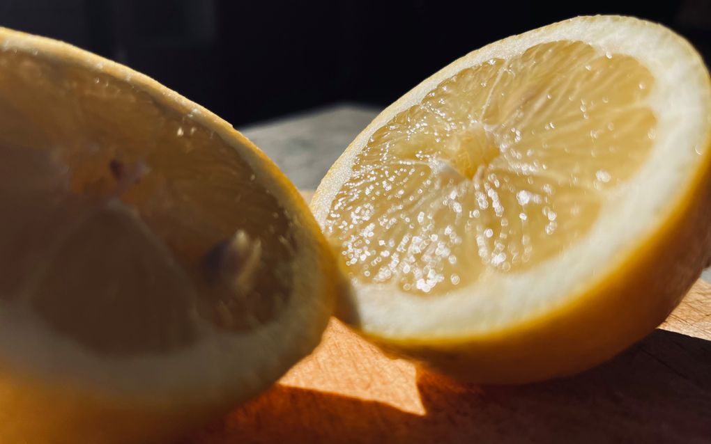 Twee halve citroenen op een snijplank.