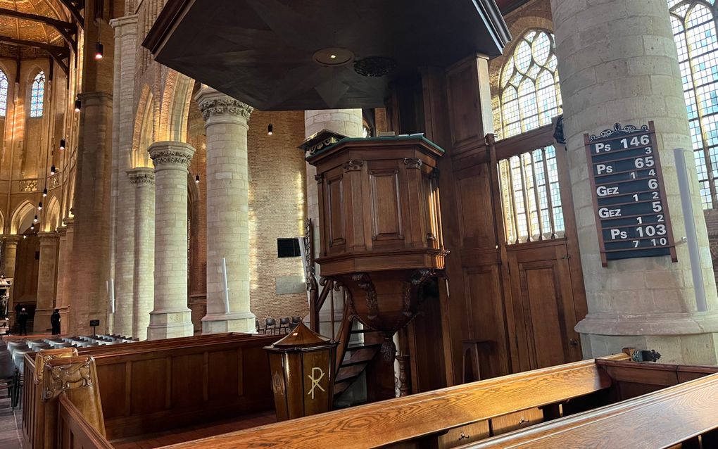 Kerkinterieur van een oude kerk, met een donkergelakte houten kansel.