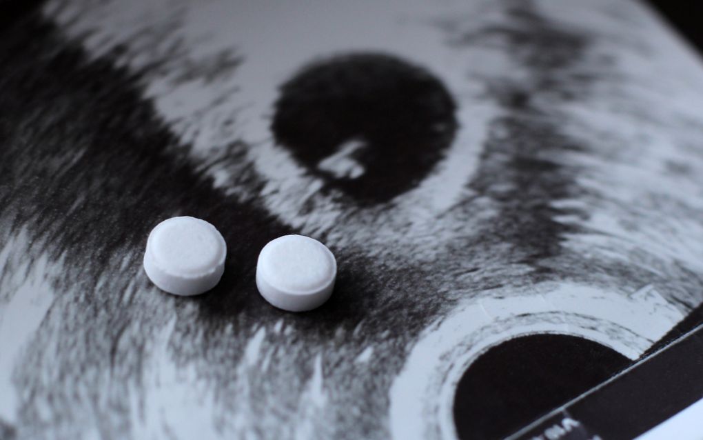 Twee witte pilletjes op de foto van een echo. 