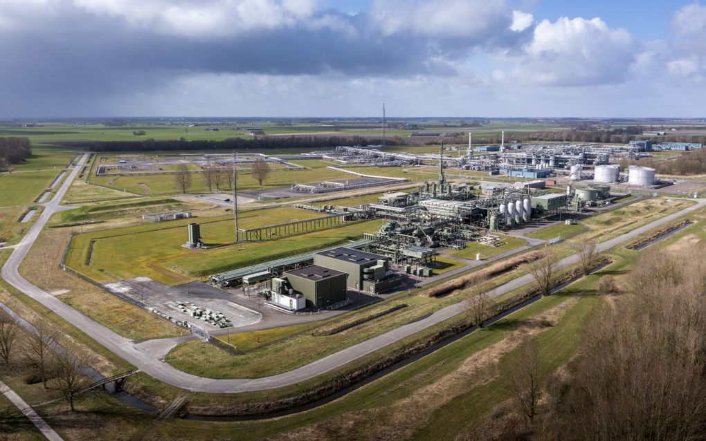 Een luchtfoto van gebouwen en installaties met grasvelden en een weg.