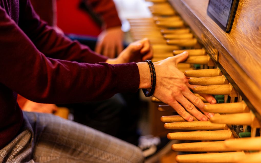 De handen van een beiaardier gaan over de stokken van een beiaardklavier.