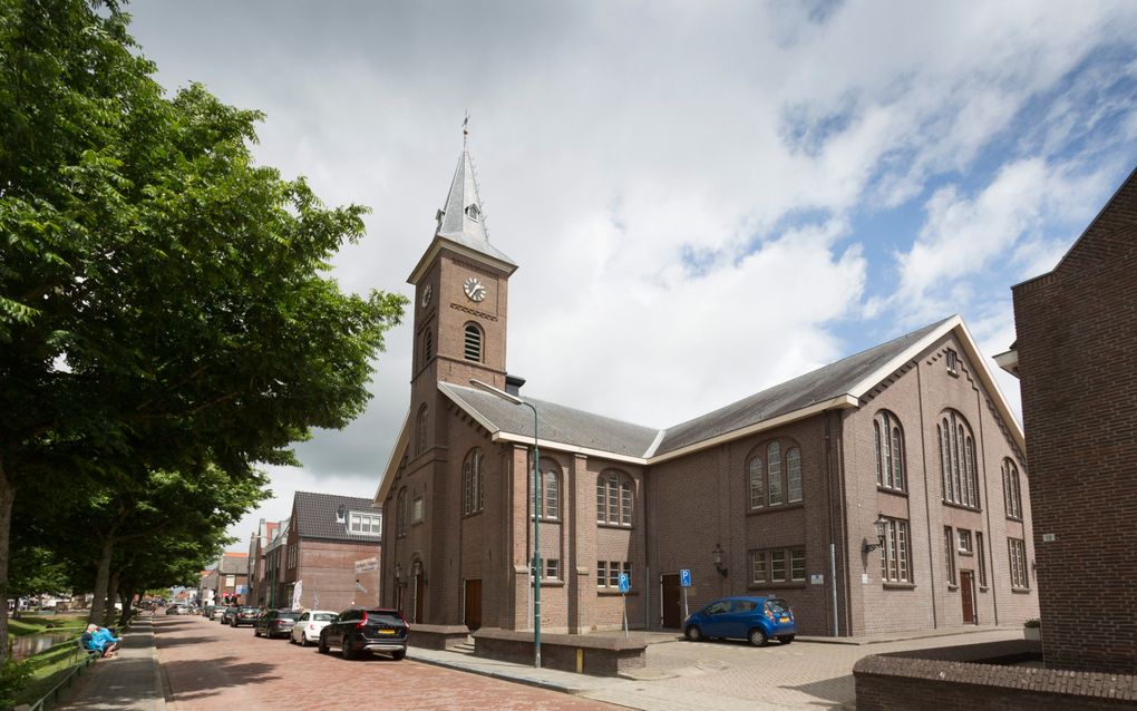 Een kerk met een torentje aan een  rustige straat.