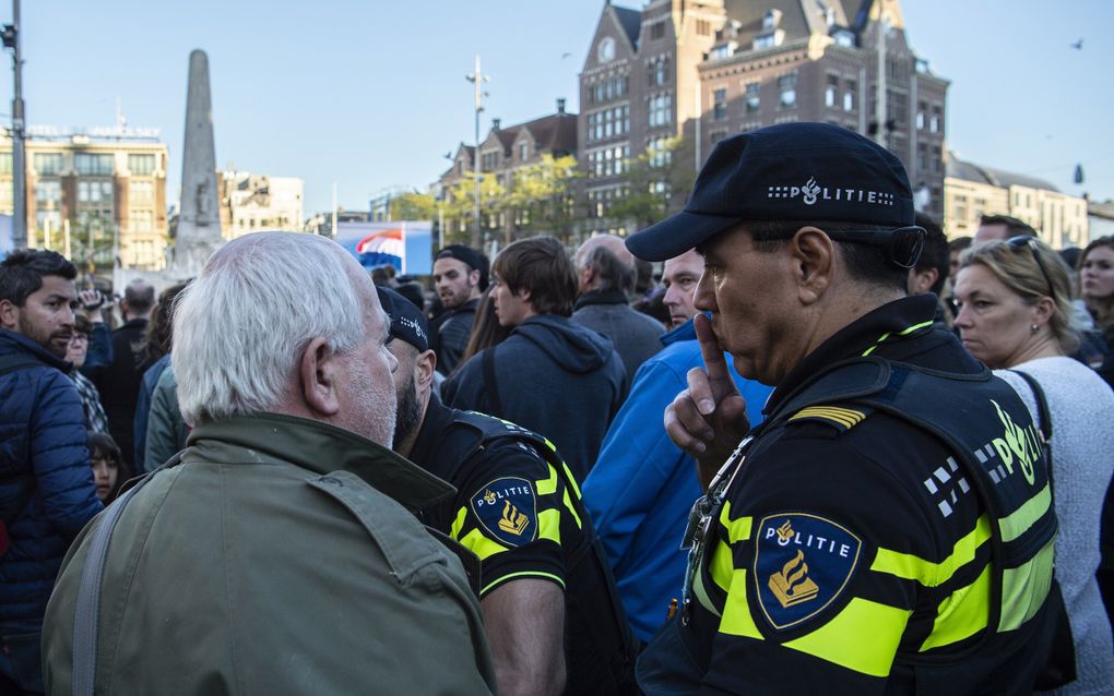 Een man met een spandoek wordt gearresteerd bij de Nationale Dodenherdenking op de Dam. beeld ANP, Robert Oostenbroek