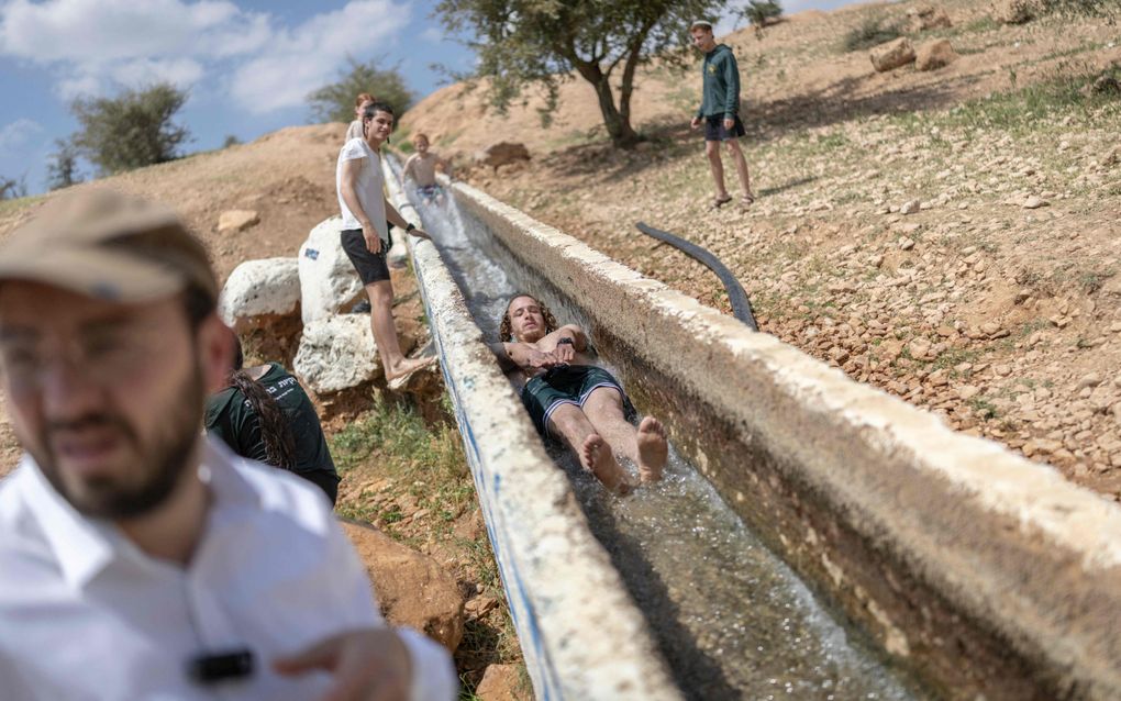 Jongeren in een kanaaltje, in een droge en zonnige omgeving.