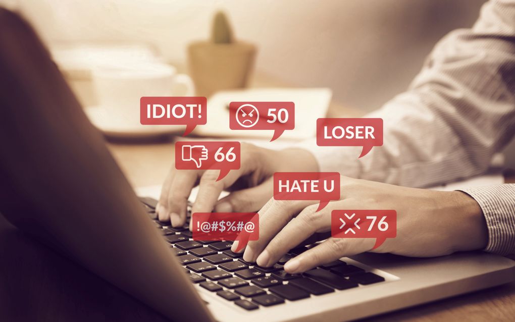 Twee handen op het toetsenbord van een laptop. Eromheen staan rode wolkjes met hatelijke teksten en icoontjes.