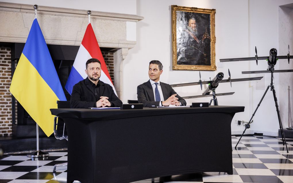 Twee mannen voor vlaggen van Nederland en Oekraïne.