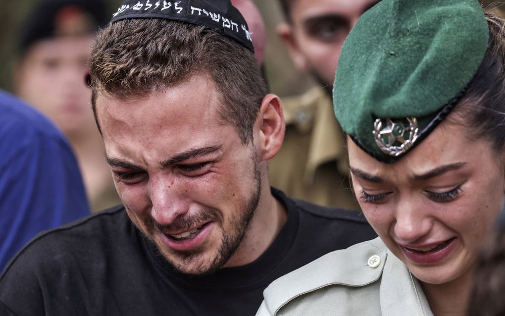 Israëliërs rouwen om de dood van een vriend die in kibboets Be’eri door Hamasterroristen om het leven is gebracht. beeld AFP, Ronaldo Schemidt