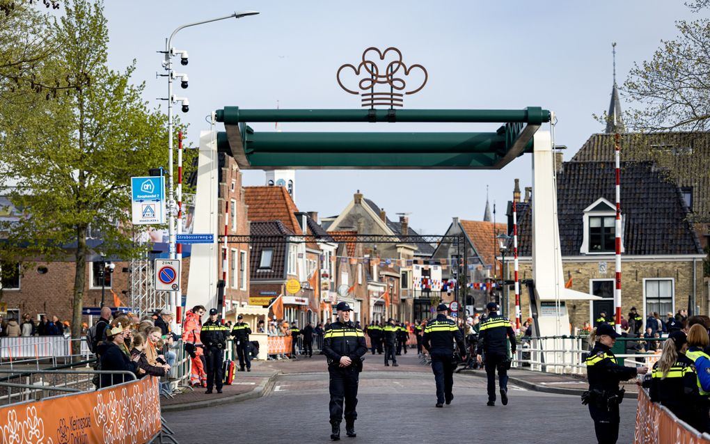 Enkele tientallen agenten staan verspreid rondom een groen-witte ophaalbrug. Op de brug staat een stalen constructie met drie harten zoals die ook in de Friese vlag te vinden zijn en drie horizontale strepen, die samen de vorm van een kroon aannemen.
