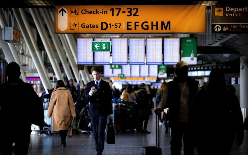 Reizigers op luchthaven Schiphol. Hoewel meer Nederlanders dan in 2019 zich zorgen maken over klimaatverandering, zijn mensen nauwelijks bereid hun gedrag aan te passen. beeld ANP, Ramon van Flymen