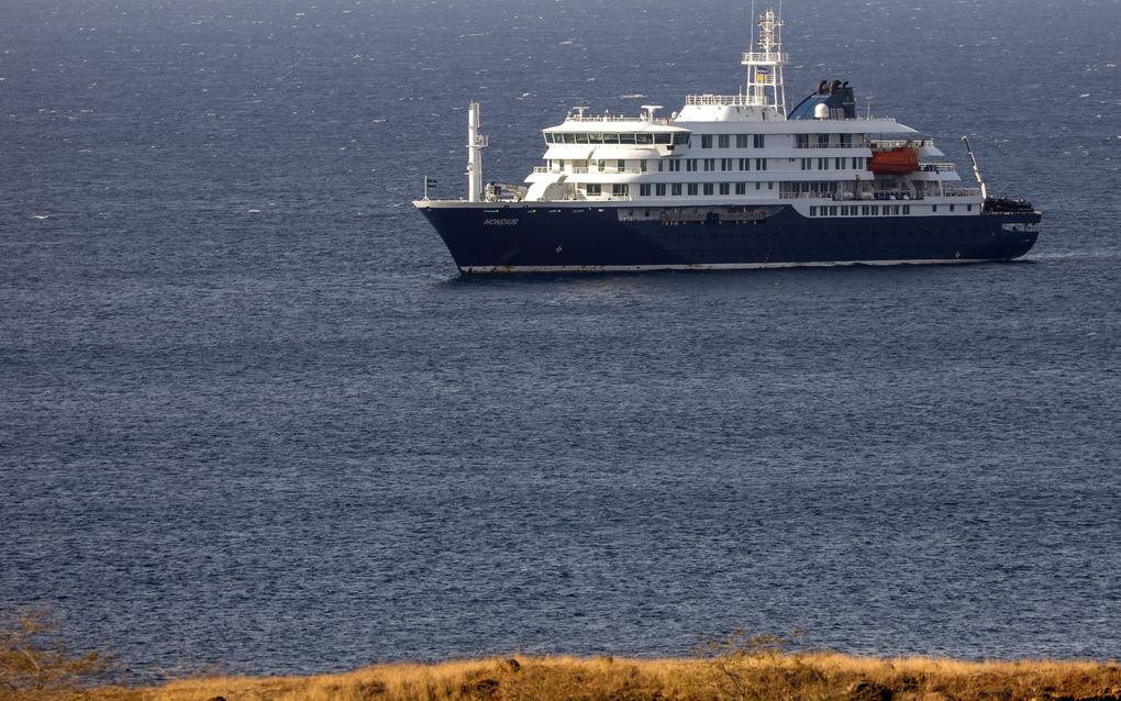Een blauw-wit schip ligt in een blauwe zee.