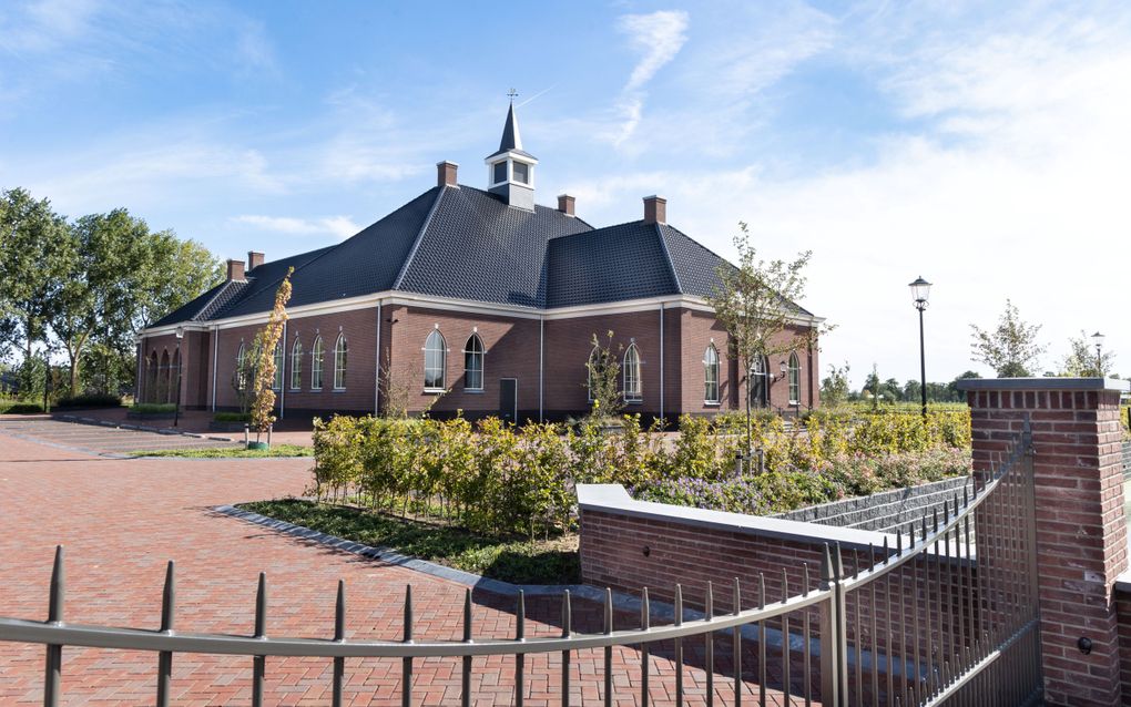 Kerkgebouw, opgetrokken uit grijsrode bakstenen. Op het dak liggen antracietkleurige pannen.
