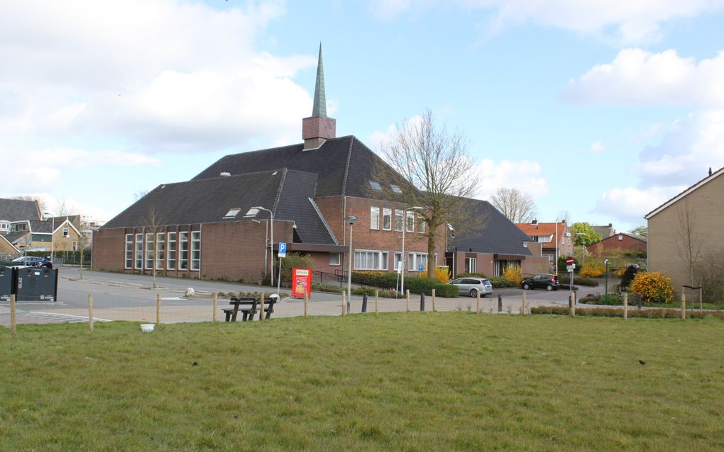 Een wat ouder kerkgebouw, met een spitsje. Op de voorgrond grasland.