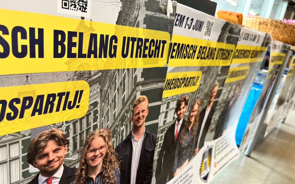 Flyers met drie partijkandidaten hangen aan een tafel. 