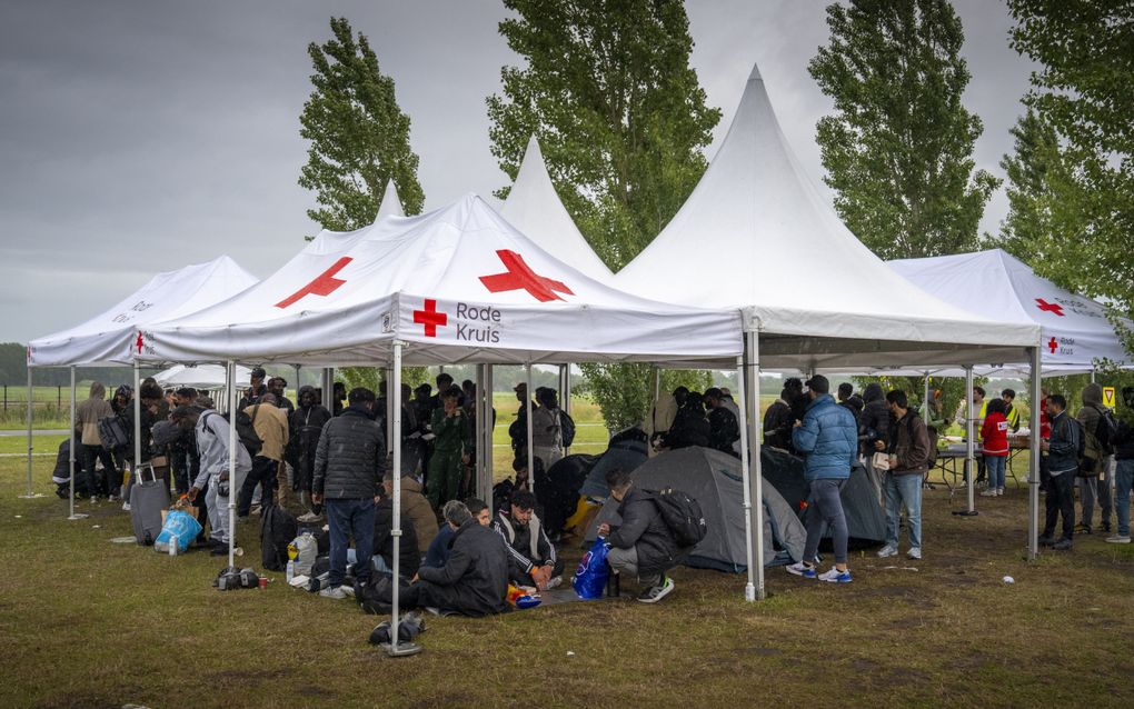 Mensen zitten onder witte tenten