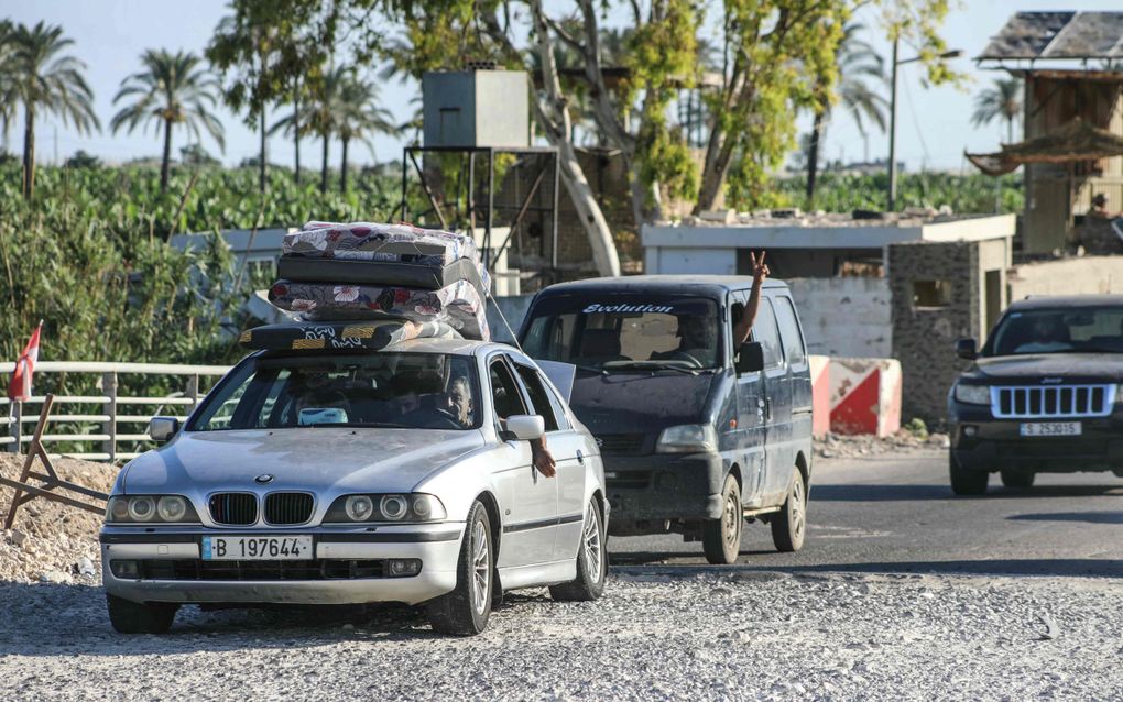 Auto met stapel matrassen op het dak rijdt over gravelweg.