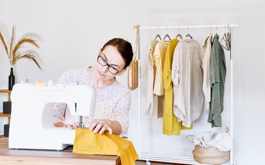 Kleding repareren is een van de manieren om de verleiding van nieuwe modetrends te weerstaan. beeld iStock 