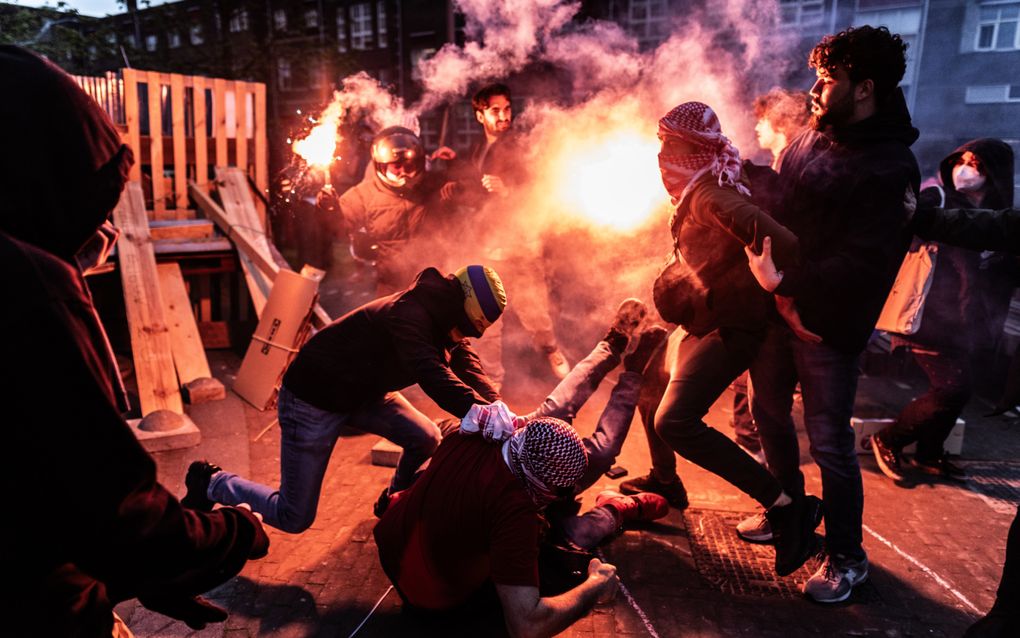 Pro-Israël demonstranten botsen met pro-Palestijnse demonstranten bij de campus van de Universiteit van Amsterdam (UvA) op het Roeterseiland. Bij de campus zijn tenten opgezet door demonstranten. Ze eisen onder meer dat de universiteit alle banden met Israel verbreekt. beeld ANP, Eva Plevier