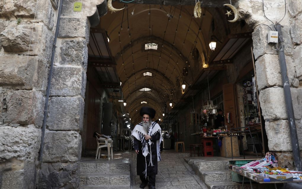 Een orthodoxe Jood verlaat de poort van de katoenhandelaren in Jeruzalem, nabij de al-Aqsamoskee op de Tempelberg. De foto is genomen tijdens het Joodse Sjavoeot of Wekenfeest in mei 2023. beeld EPA, Atef Safadi