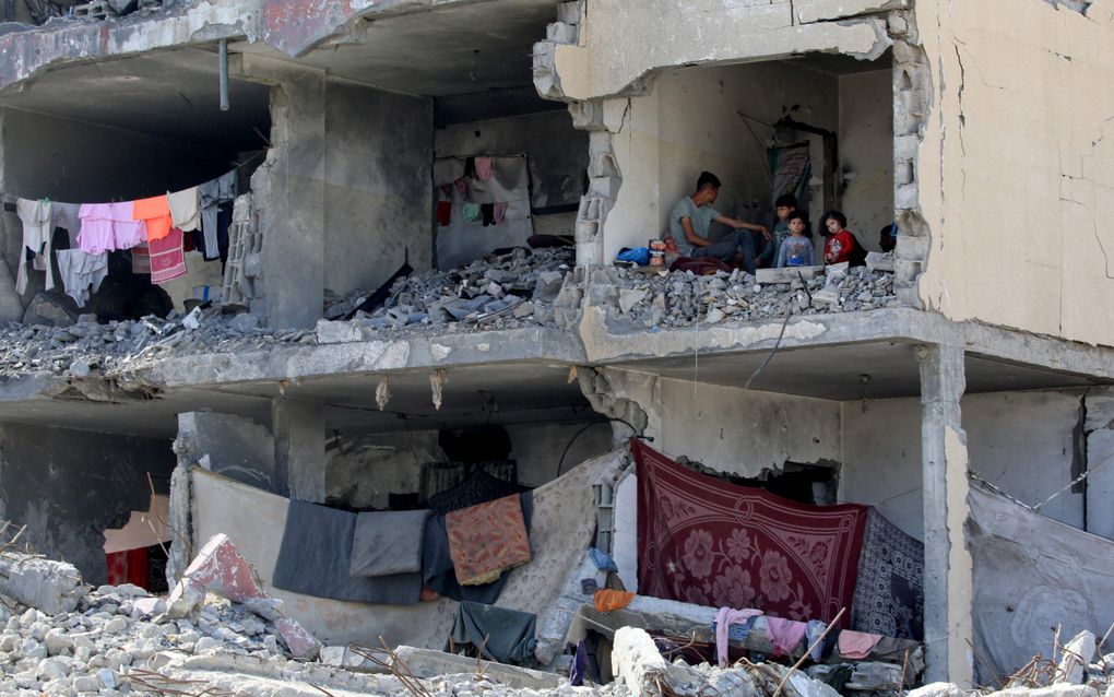 Een Palestijns gezin in een verwoest huis in Rafah. beeld AFP, Eyad AL-BABA 