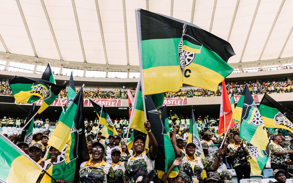 Aanhangers van het African National Congress (ANC) zwaaien met vlaggen tijdens de presentatie van het verkiezingsmanifest in een stadion in Durban op 24 februari 2024. beeld AFP, Rajesh Jantilal