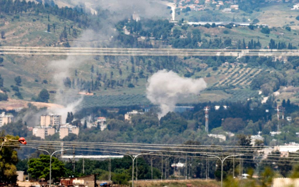 De Noord-Israëlische stad Kiryat Shmona, tegen de grens met Libanon aan, is inmiddels meermalen bestookt door raketten van Hezbollah. Deze foto dateert van 5 mei: rook stijgt op na raketinslagen. beeld AFP, Jalaa Marey