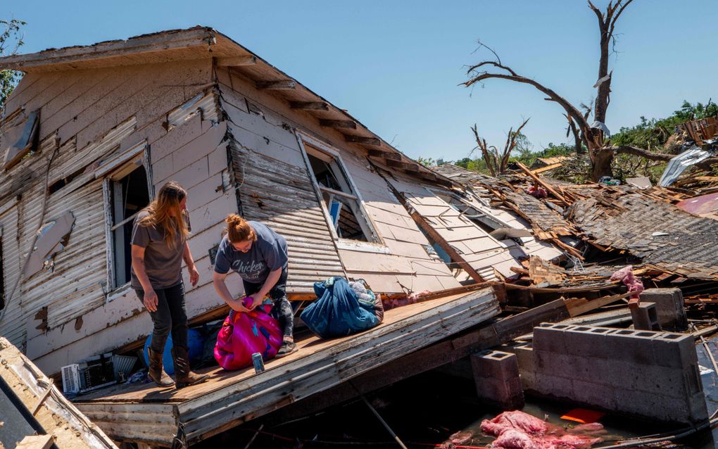 De familie Crowder uit Oklahoma verzamelt bezittingen nadat hun huis totaal is verwoest door een tornado, begin mei. Afgelopen weekend was het opnieuw raak in diverse staten. beeld AFP, Brandon Bell