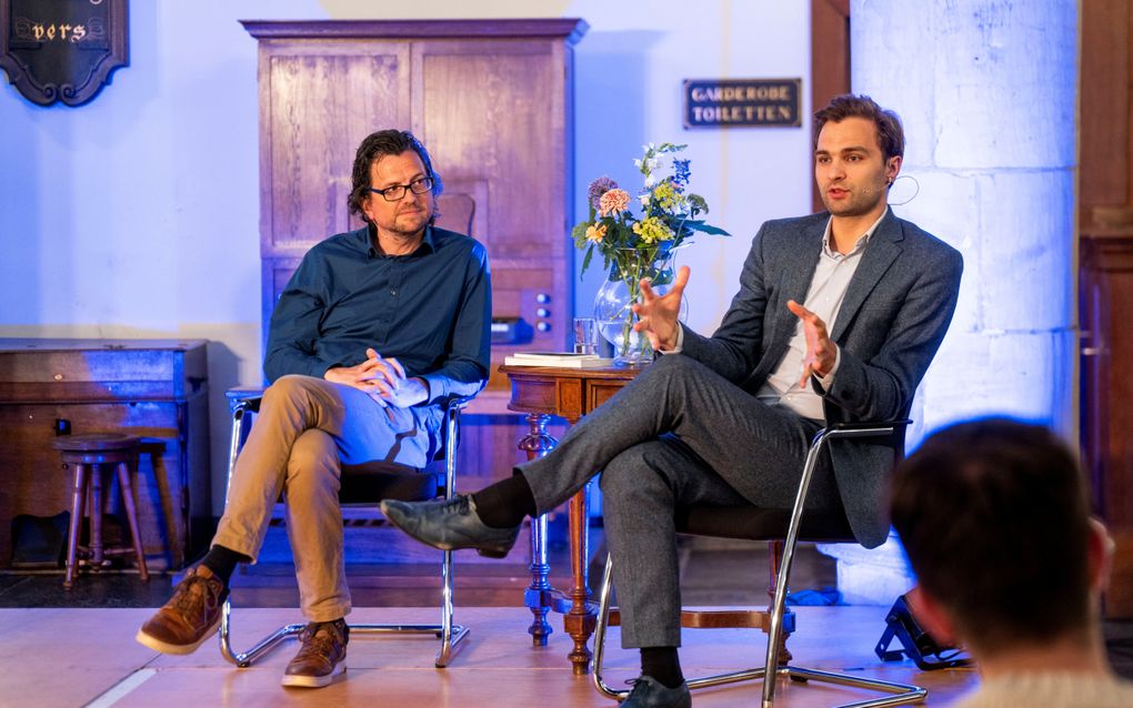 Auteur Wouter de Koning en demissionair staatssecretaris Maarten van Ooijen tijdens een debatavond over suïcide in de Pelgrimvaderskerk in Rotterdam. beeld Van der Wal Fotografie, Martijn de Zwart