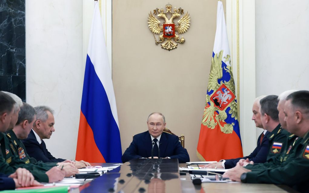 De Russische president Vladimir Poetin (m.) spreekt in het Kremlin in Moskou met de commandanten van de militaire districten. De ontmoeting had vorige maand plaats. beeld AP, Vyacheslav Prokofyev