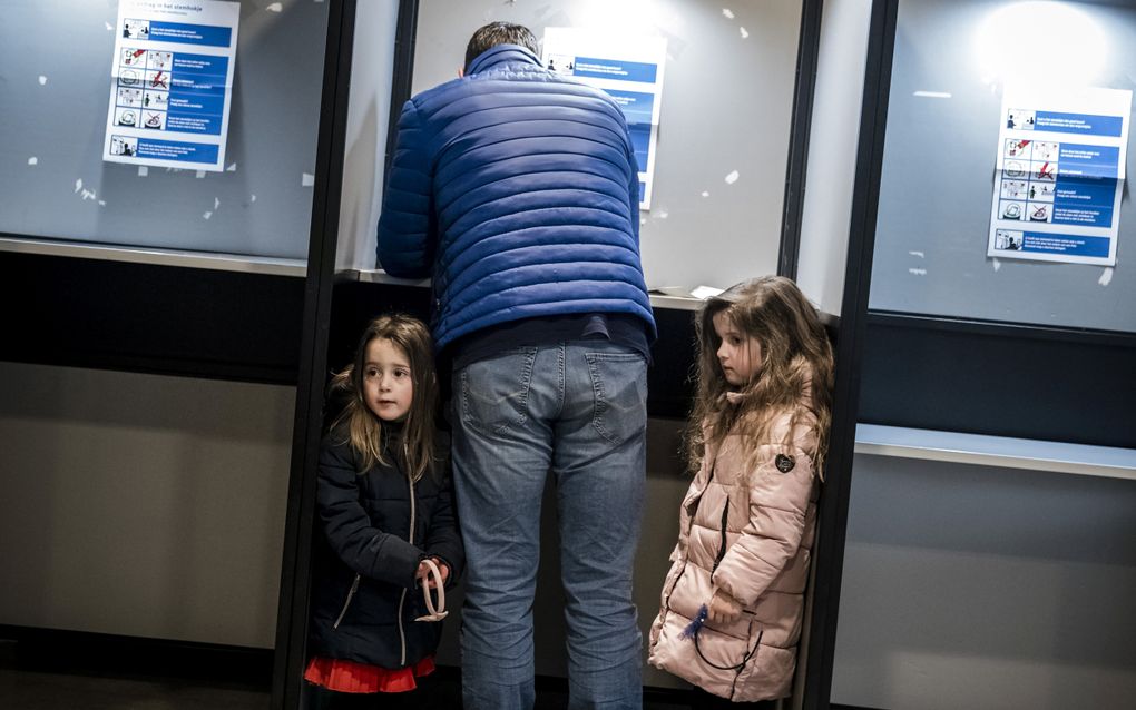 Jong geleerd is oud gedaan, zal deze vader gedacht hebben. Over de vraag of de leeftijdsgrens om te stemmen omlaag moet, zijn de meningen verdeeld. beeld ANP, Rob Engelaar