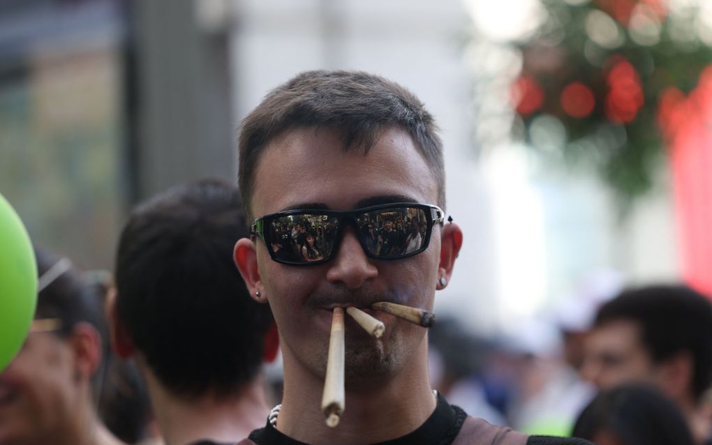 Een man met drie joints in zijn mond. beeld AFP, Pierre-Philippe Marcou