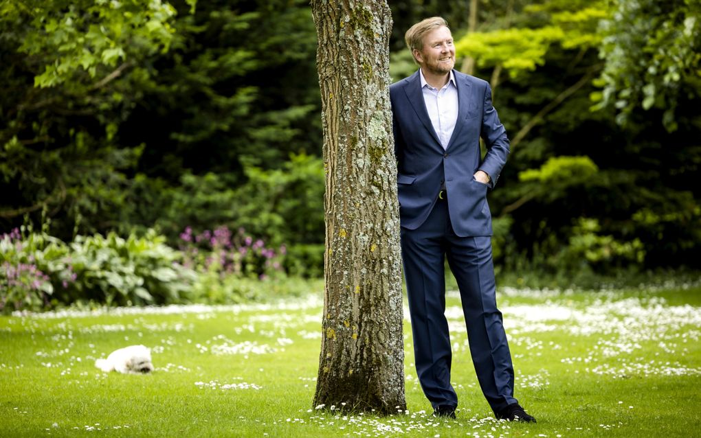 Koning Willem-Alexander met hond Mambo tijdens de traditionele fotosessie van de koninklijke familie op Paleis Huis ten Bosch. beeld ANP, Sem van der Wal 