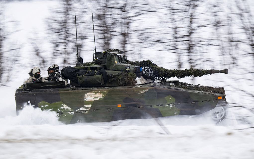 Zweedse militairen rijden in een CV90-pantserwagen. Het voertuig beschikt over een 35 mm-snelvuurkanon en zware bepantsering. beeld AFP, Jonathan Nackstrand