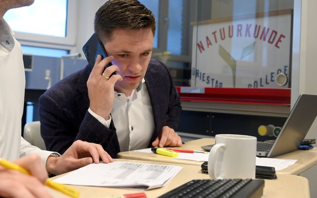 Leander Tramper belt een van zijn mentorleerlingen op met de examenuitslag. beeld Paul Dijkstra 