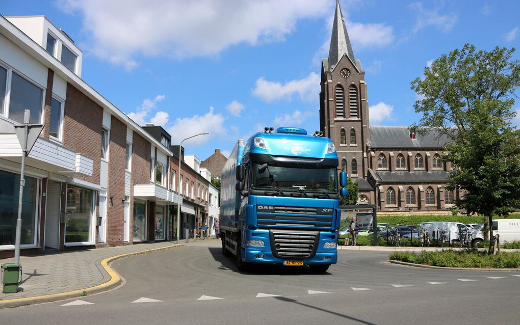 Damian stuurt zijn oude DAF XF 105 460 achteruit en parkeert naast de rooms-katholieke kerk om bij de laatste klant te lossen. beeld Sjaak van de Groep