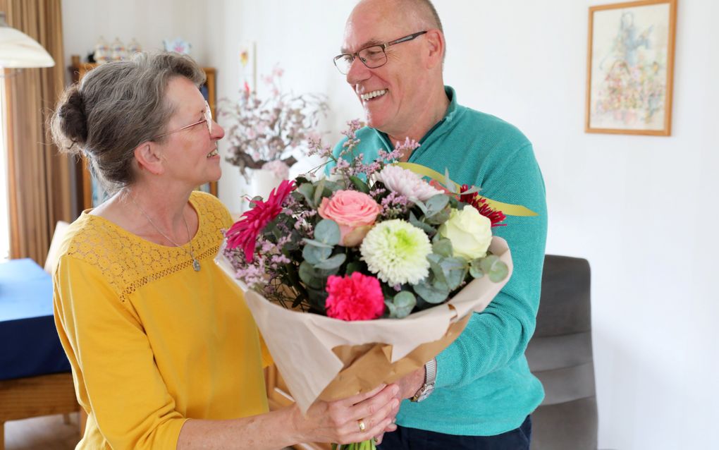 Henk van Zetten geeft een bloemetje aan zijn vrouw. Van Zetten heeft een herseninfarct gehad en wordt door zijn vrouw verzorgd. beeld VidiPhoto