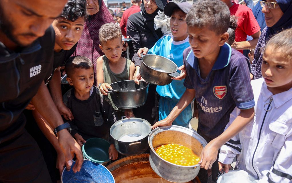 Kinderen staan in de rij voor eten bij een UNRWA-school in vluchtelingenkamp Jabalia in het noorden van de Gazastrook. beeld AFP, Omar Al-Qattaa