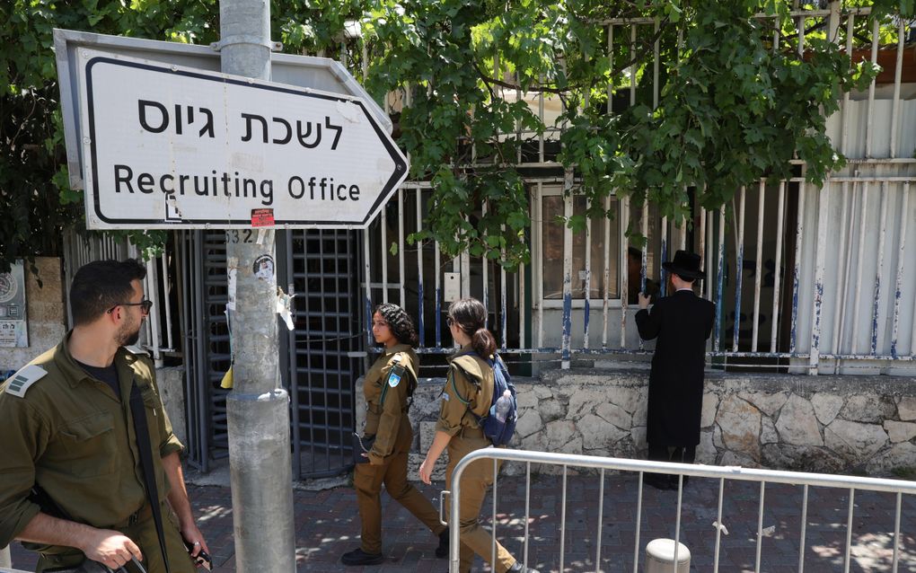 Een ultraorthodoxe man staat bij een rekruteringskantoor van het Israëlische leger in Jeruzalem. beeld EPA, Abir Sultan