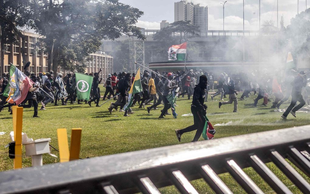 Demonstranten bestormen het terrein van het Keniaanse parlement in Nairobi. beeld AFP, Luis Tato