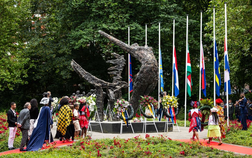 Bestuursleden van het Nationaal instituut Nederlands slavernijverleden en erfenis (NiNsee) maandagmiddag tijdens de kranslegging in het Oosterpark in Amsterdam. beeld ANP, Robin van Lonkhuijsen