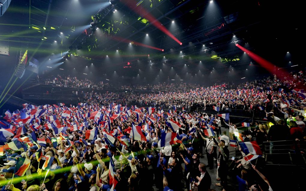 Mensen zwaaien dinsdag met Franse vlaggen tijdens een rally van de rechts-nationalistische partij Rassemblement National (RN) in Parijs. beeld AFP, Stephane de Sakutin