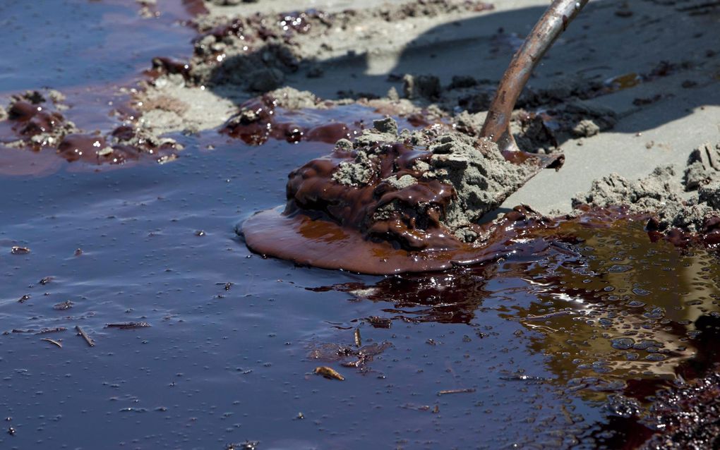 Olie wordt vand de stranden geschept. Foto EPA