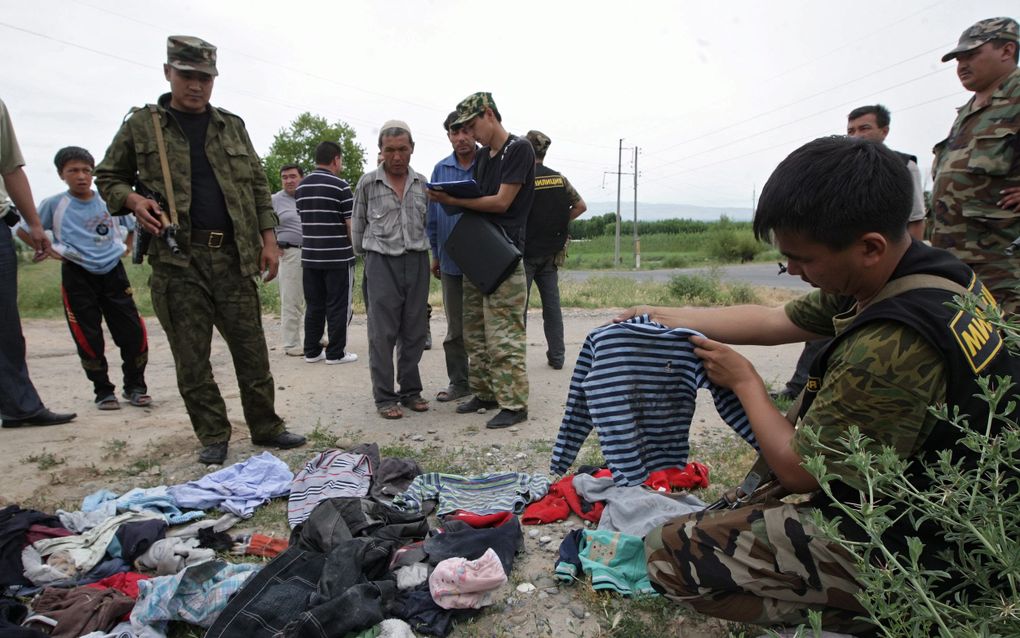 Soldaten tonen kleren van vermoorde Kirgizische burgers. Foto EPA