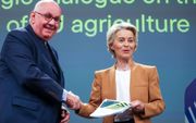 Voorzitter Ursula von der Leyen van de Europese Commissie (r.) ontvangt het rapport van de strategische dialoog over de toekomst van de landbouw in Europa uit handen van dialoogvoorzitter Peter Stroschneider. beeld EPA, Olivier Hoslet