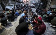 In Rafah eten mannen de iftarmaaltijd tijdens de Ramadan. beeld AFP, MOHAMMED ABED