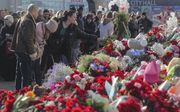 Russen legden maandag bloemen bij de concertzaal waar vrijdagavond een aanslag werd gepleegd. Zeker 137 mensen kwamen om. beeld EPA, Maxim Sjipenkov