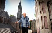 Chris van der Sman, met op de achtergrond ‘zijn’ Nieuwe Kerk in Delft. De foto is gemaakt toen ook de Utrechtse Domtoren (r.) nog op zijn erf stond. 